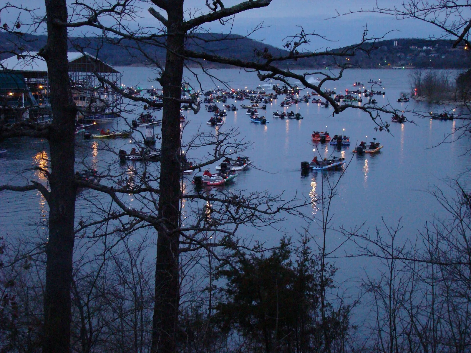 Many small boats gathered on the lake at dusk