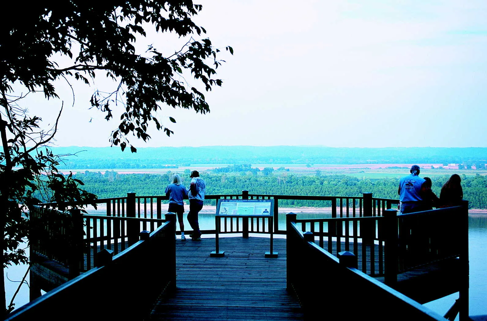 Wooden overlook deck with people looking out over a wide river valley