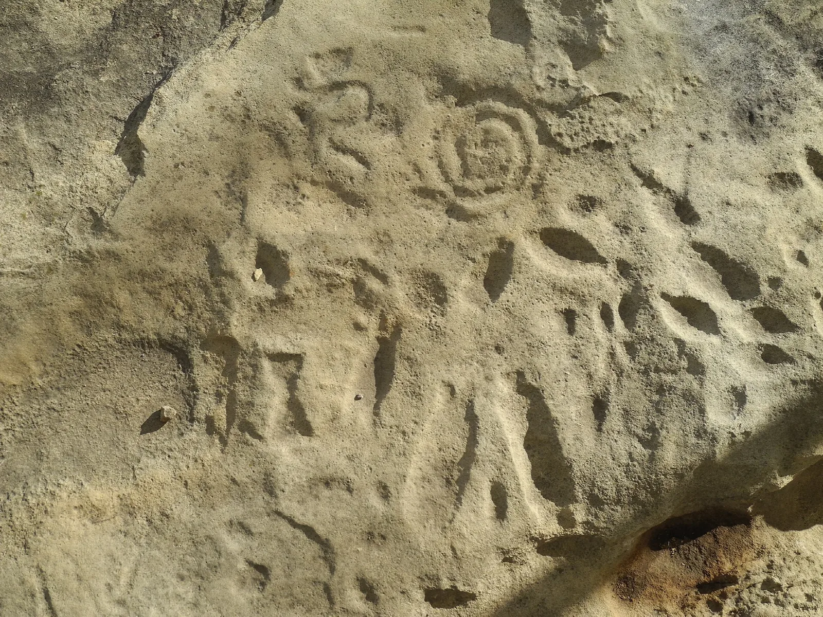 Spiral and other symbols carved into a sandstone surface
