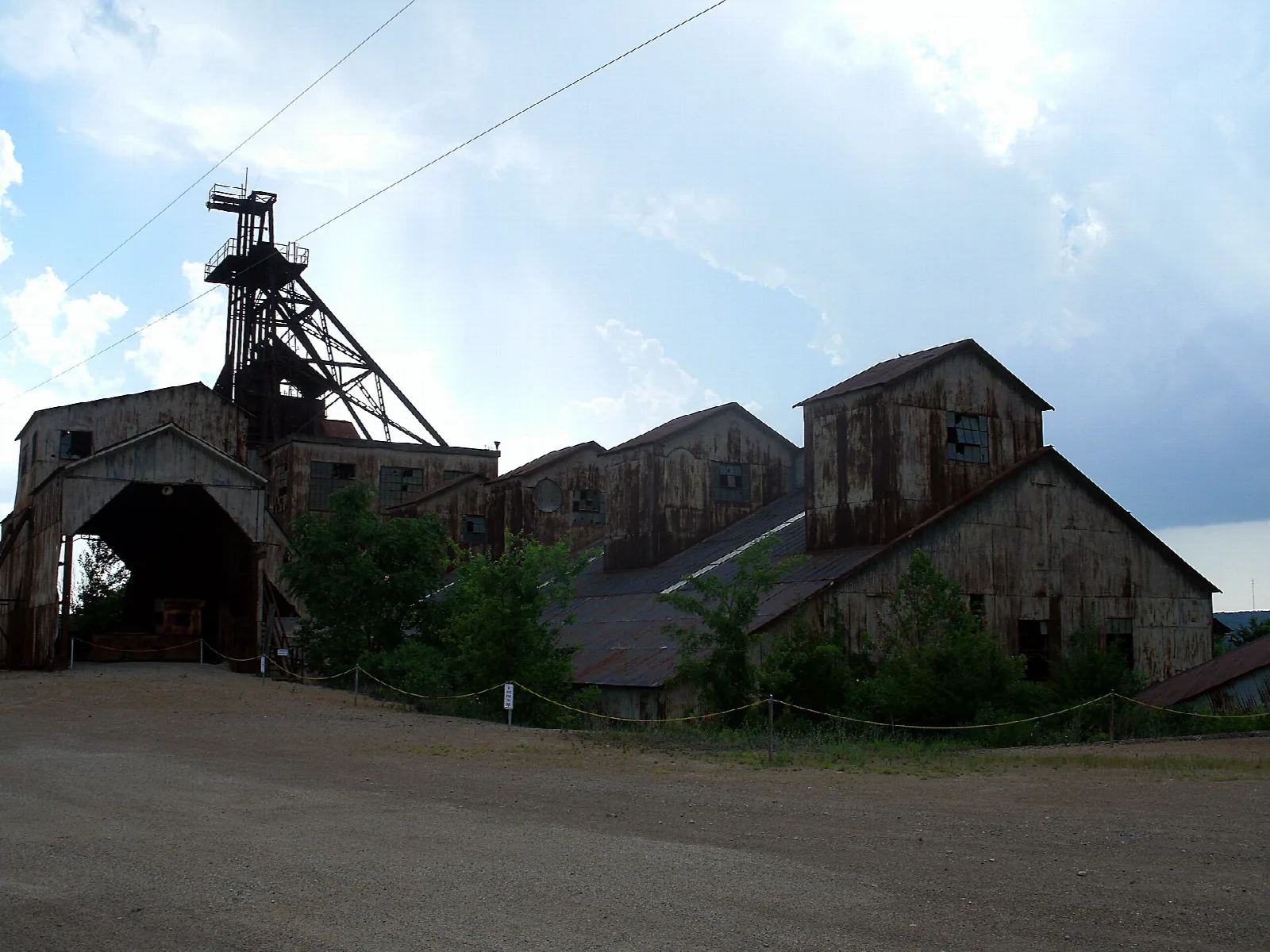 Old mine mill buildings and a headframe tower on a sunny day