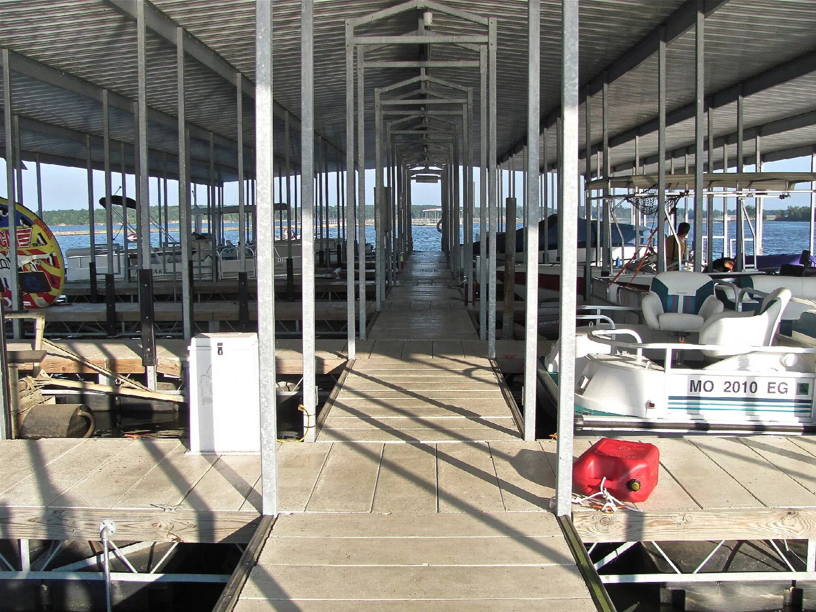 Covered boat slips with pontoon boats at a marina dock