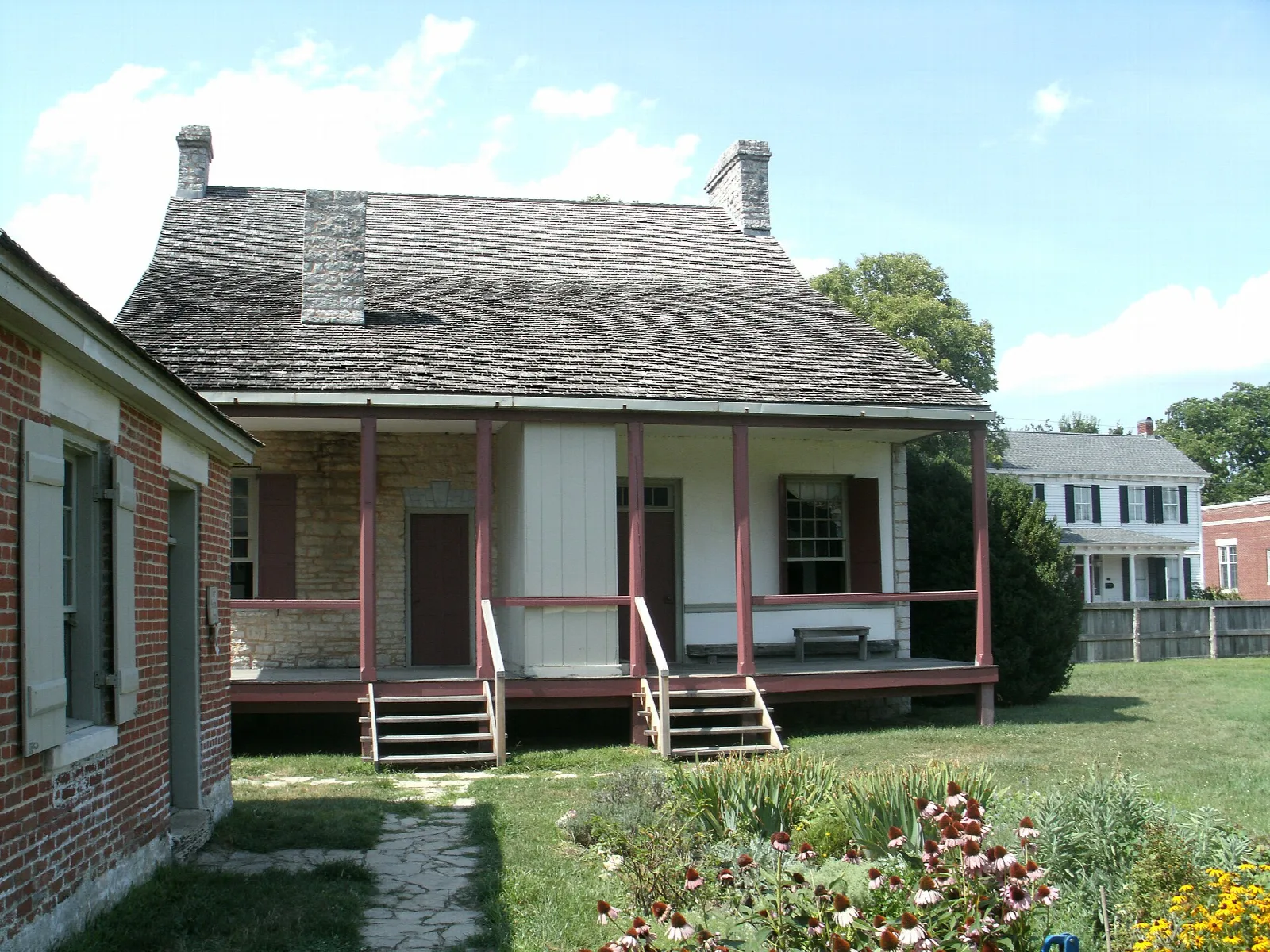 Low house with a porch and flower garden in front