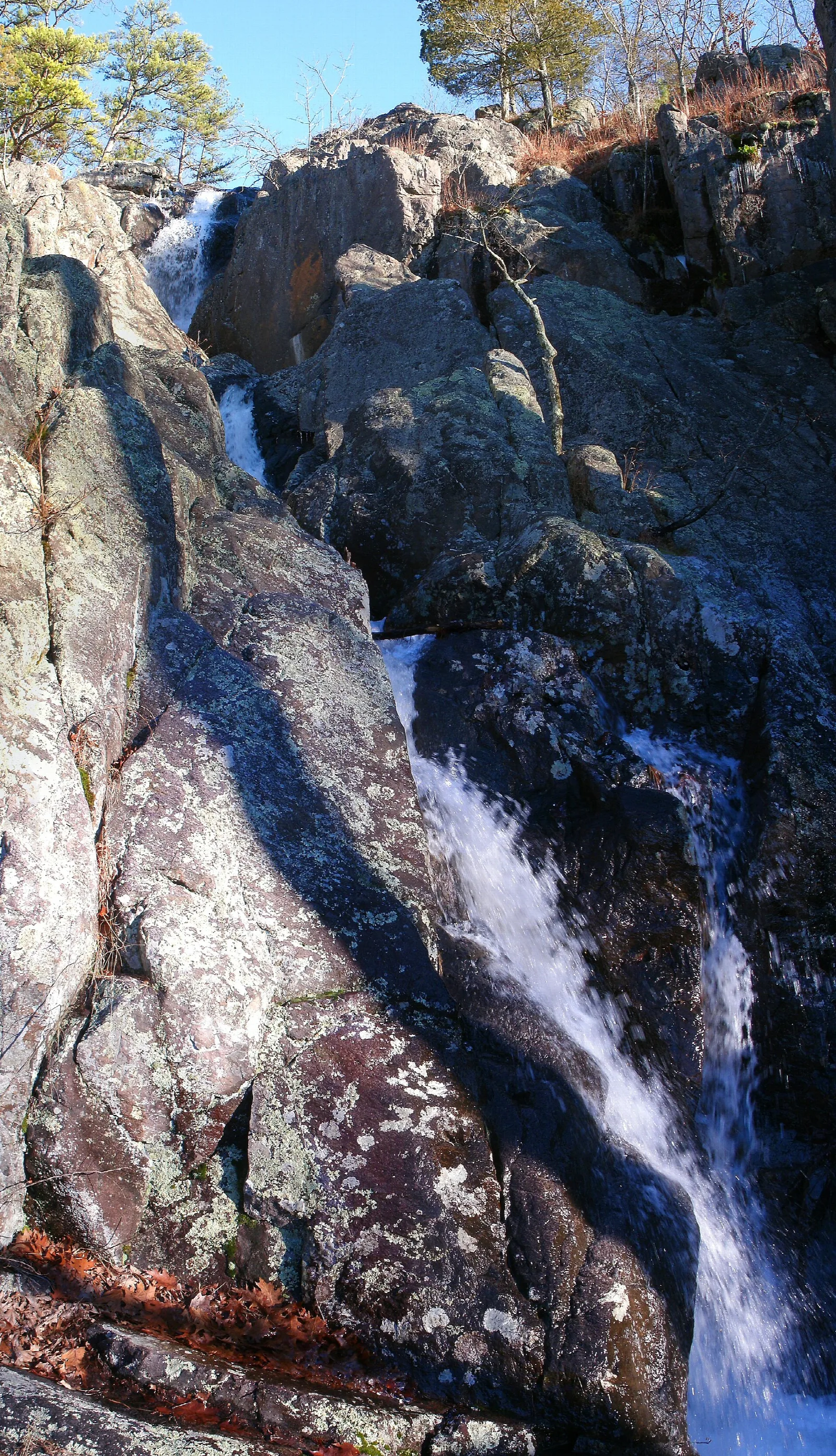 Tall waterfall dropping down a rock face among trees