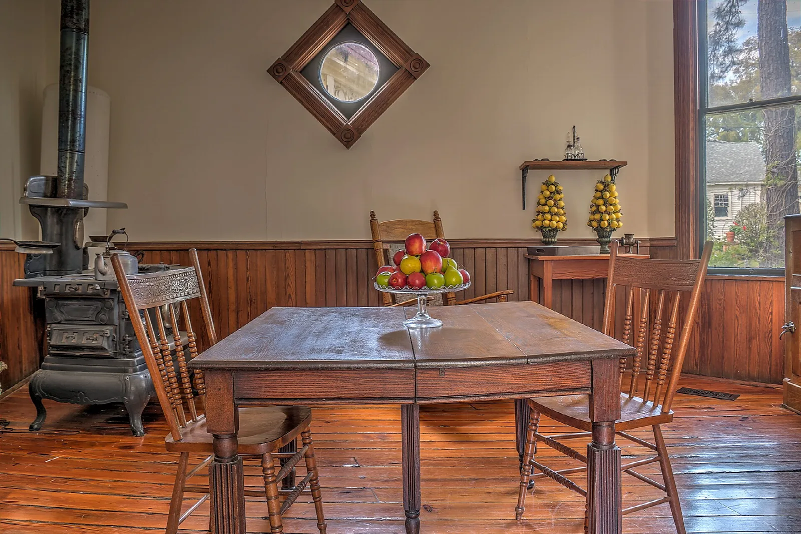 Wooden table and chairs beside an iron stove in a kitchen