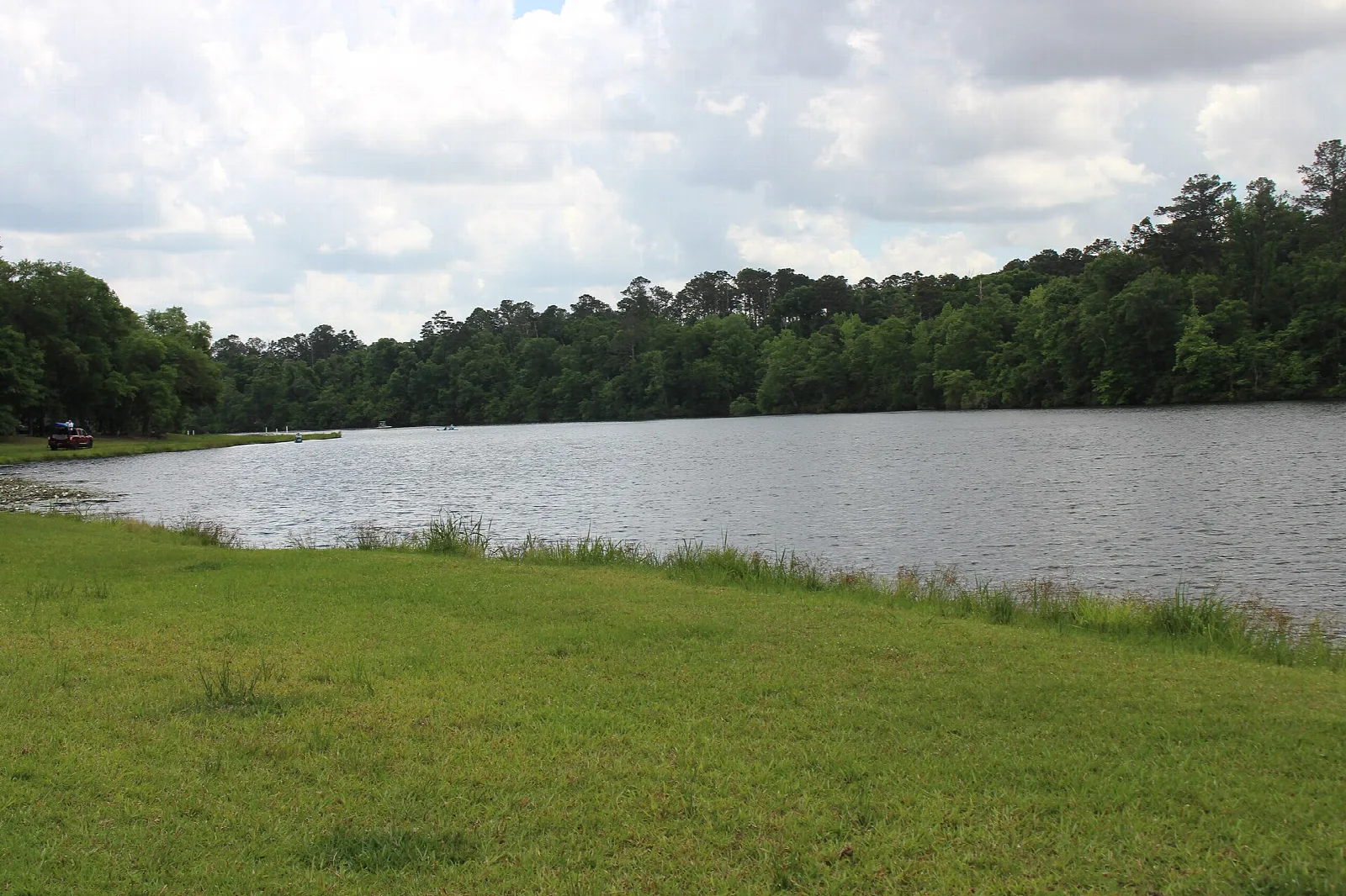 Lake bordered by a mowed lawn and forest