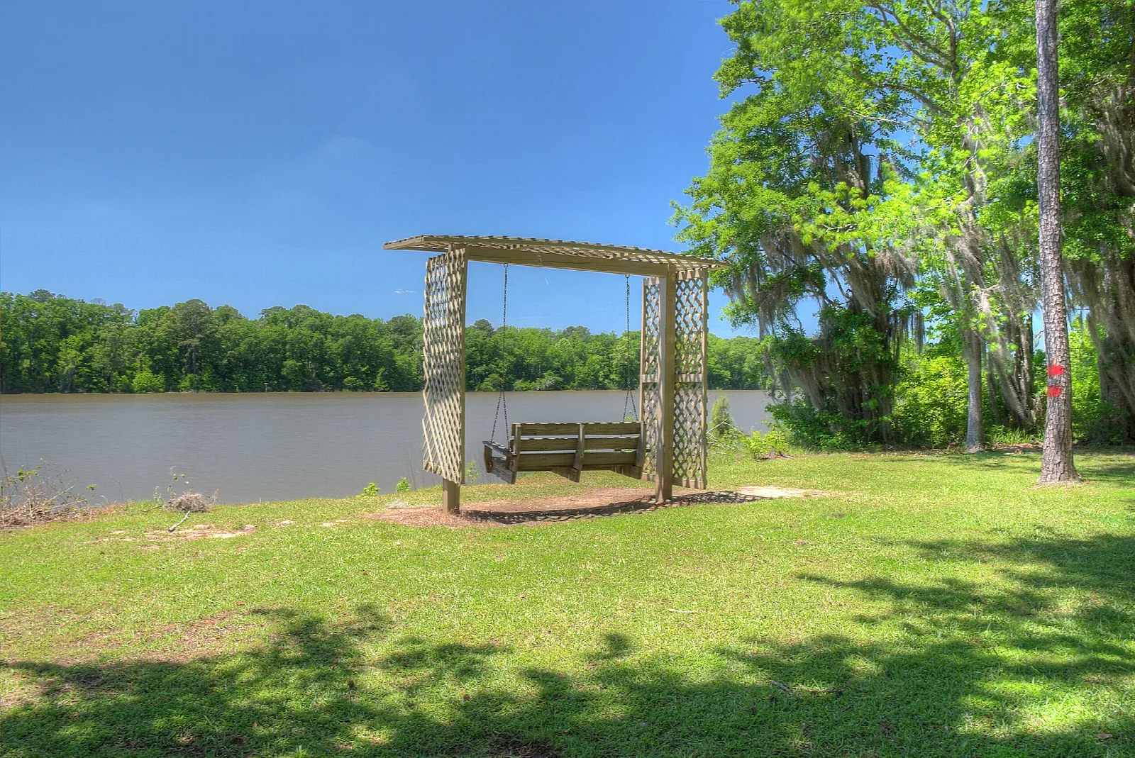 Porch swing on a lawn beside the lake