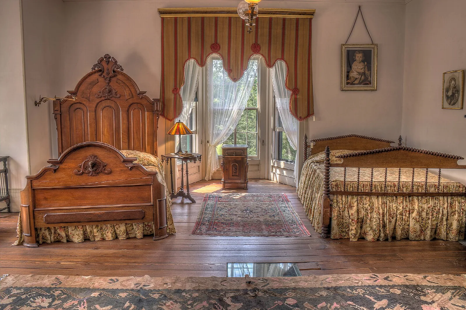 Upstairs bedroom with a carved wooden bed and a striped curtain
