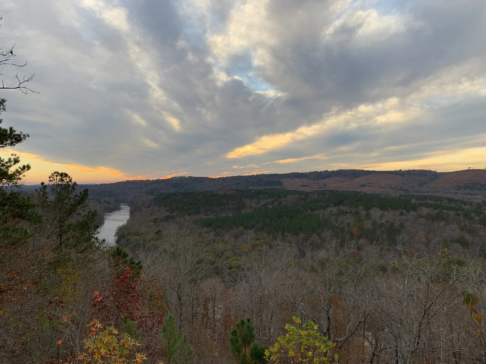 Cloudy sky over forested hills with the river visible in the distance