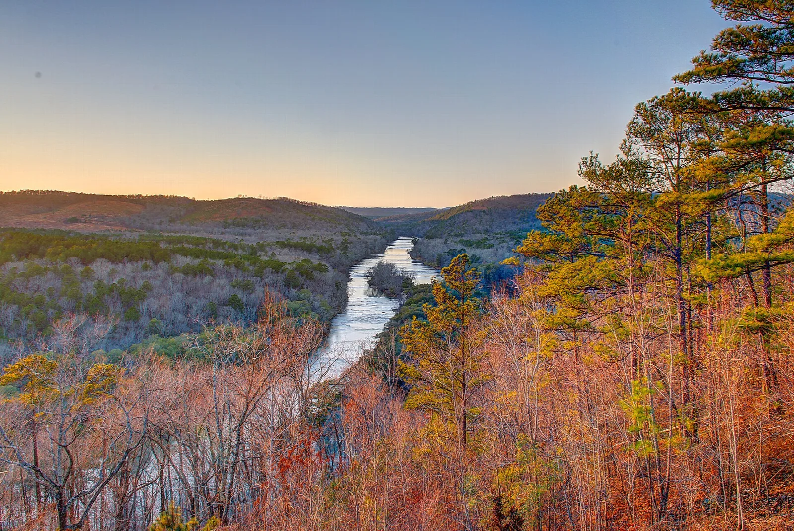 River bend seen from a hilltop through orange autumn trees