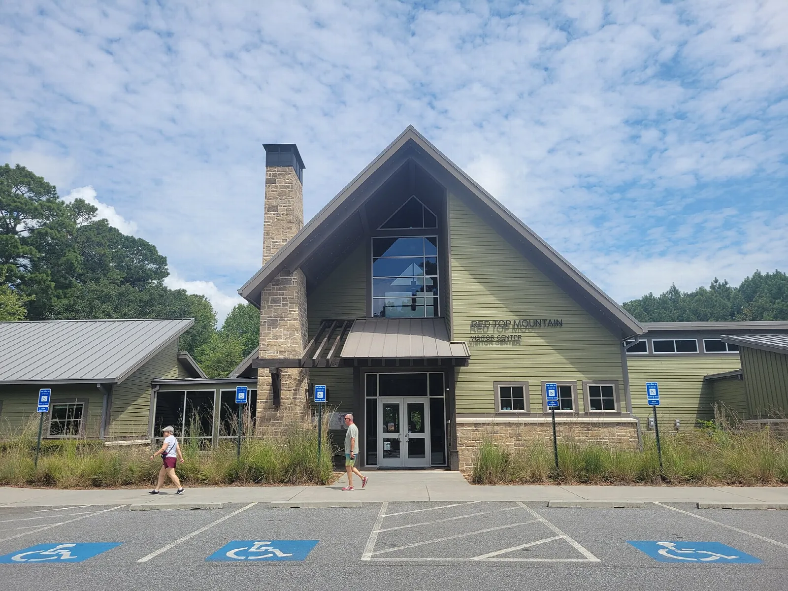 Visitor center building with a gabled entrance and stone chimney