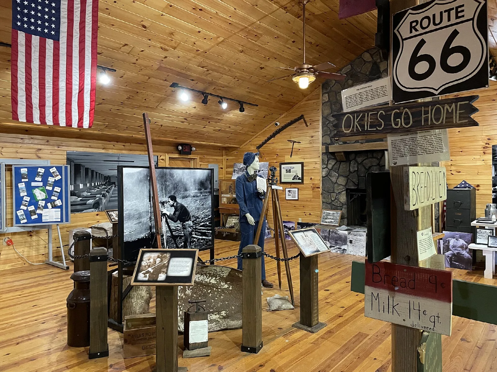 Museum room with exhibits, a flag and a Route 66 sign