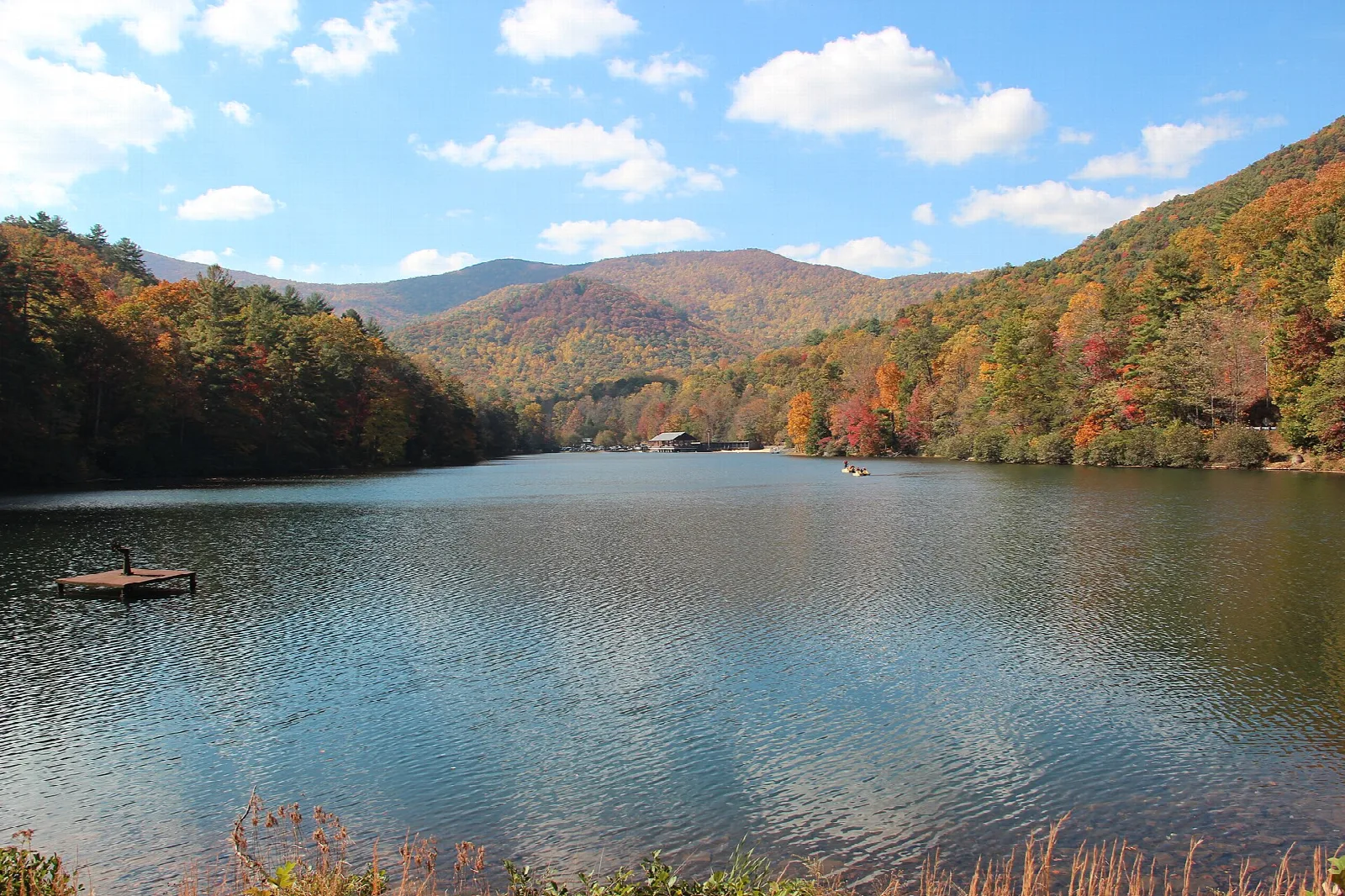 Calm lake ringed by forested hills in fall color
