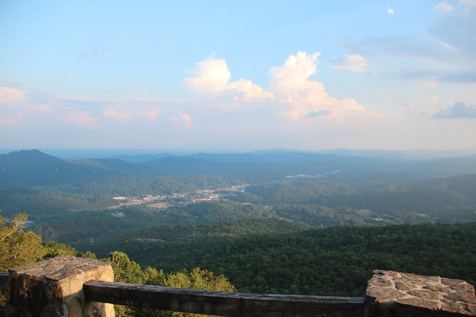 Stone overlook wall above forested valleys and distant hills