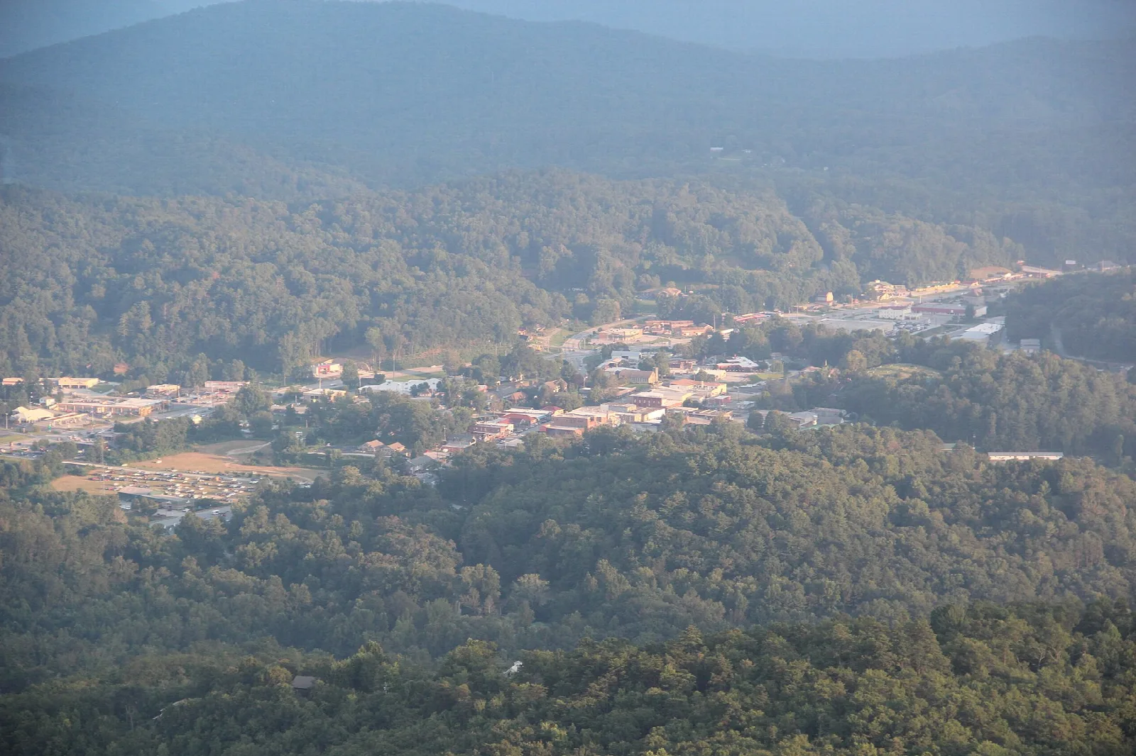 Forested mountainside above a small town in the valley