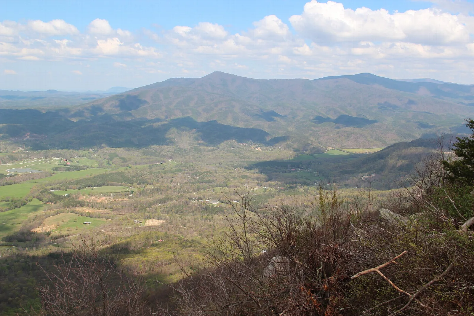 Wide view across a green valley to a distant mountain