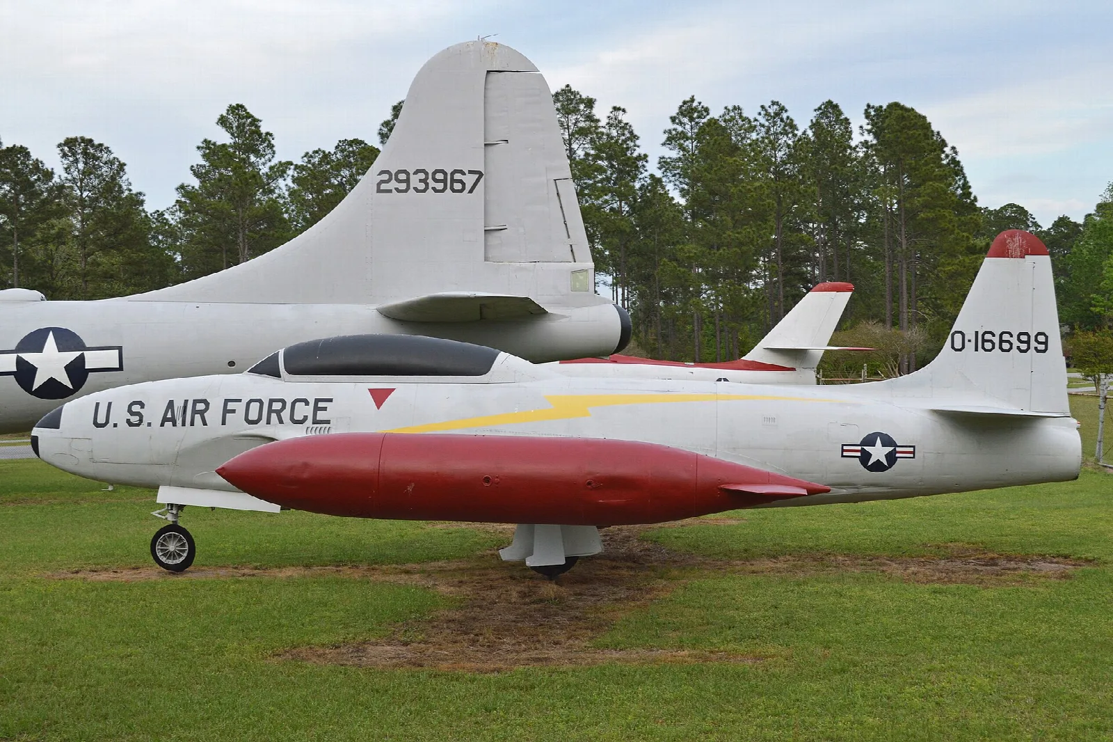 Air Force jet trainer on display in front of trees