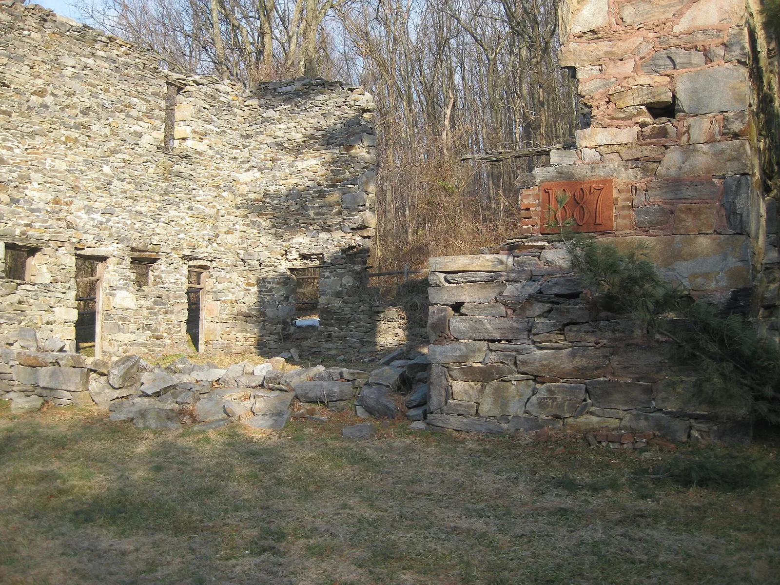 Stone ruin walls with window openings on a grassy hilltop