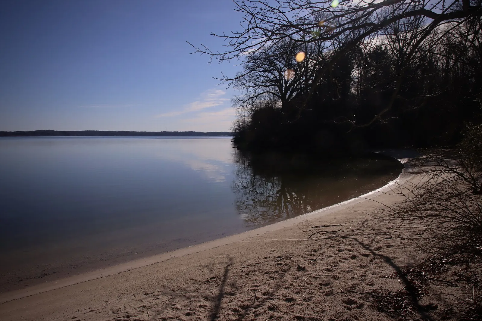 Calm river with a curved sandy beach at dusk
