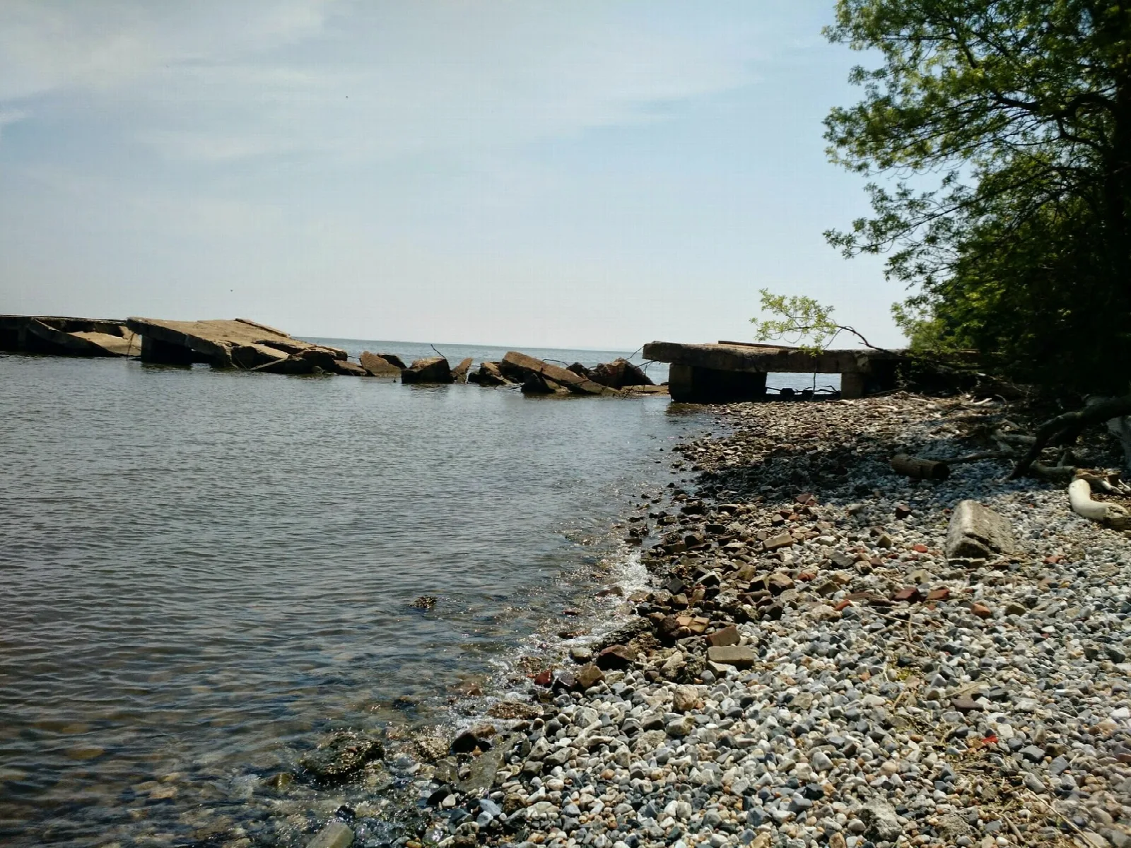 Broken stone slabs along a pebbly bay shore