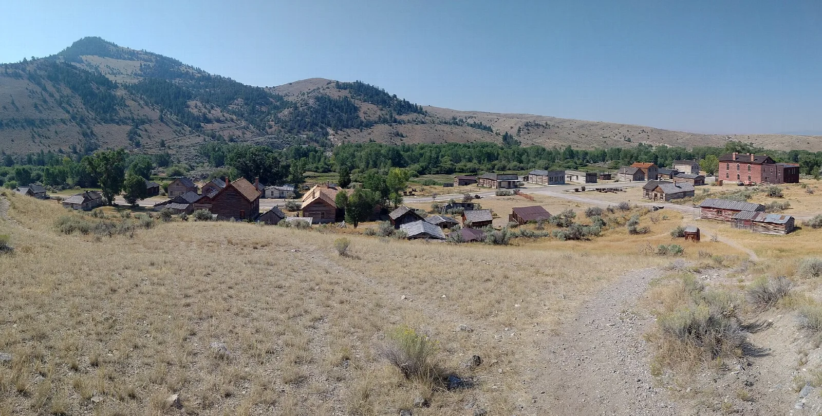 Wide view of the old town and its wooden buildings below a mountain