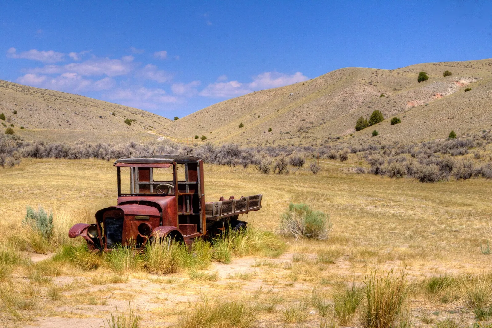 Rusted old truck in a dry grass valley
