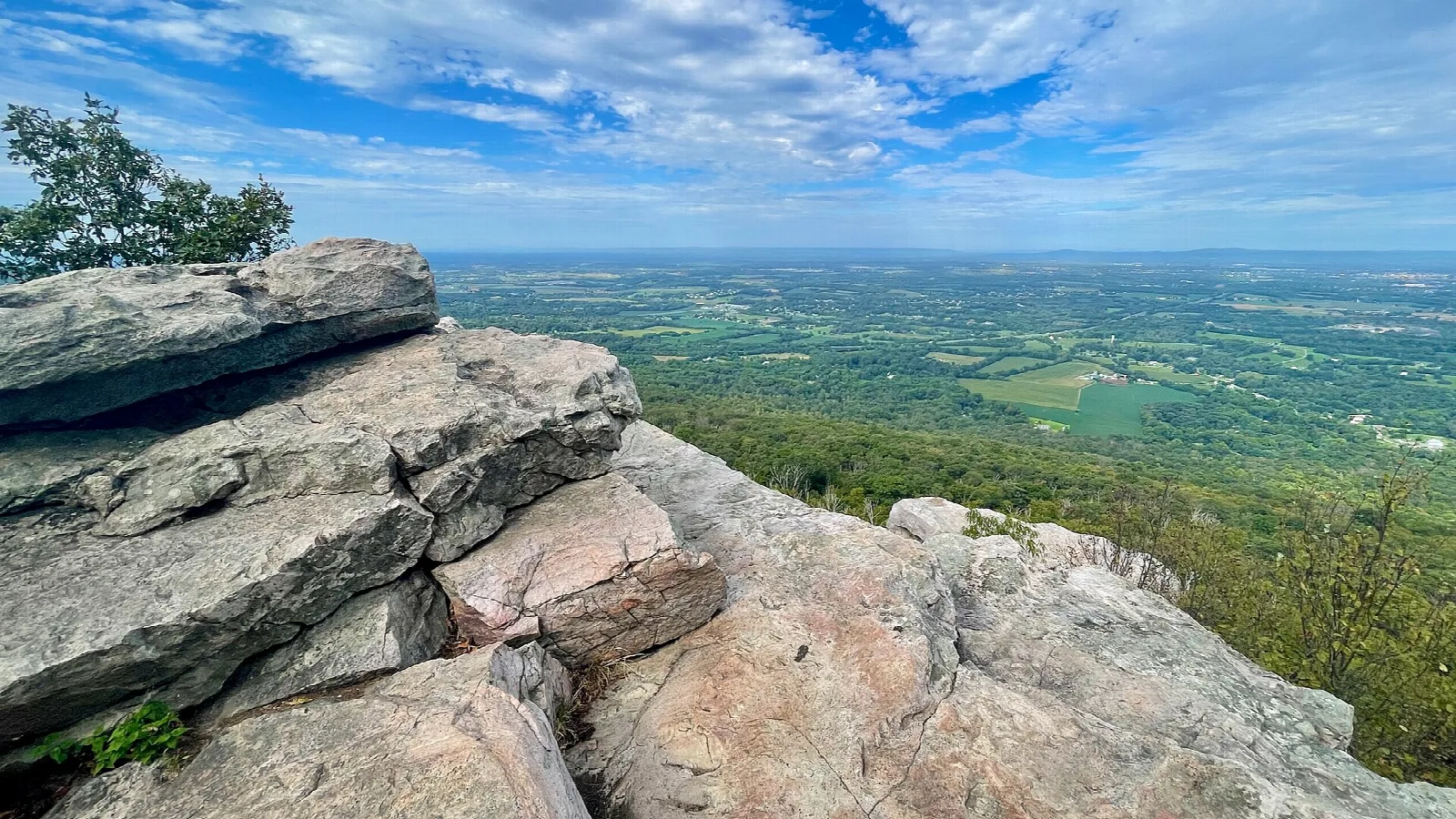 Flat rock ledge at a cliff vista over farmland and ridges