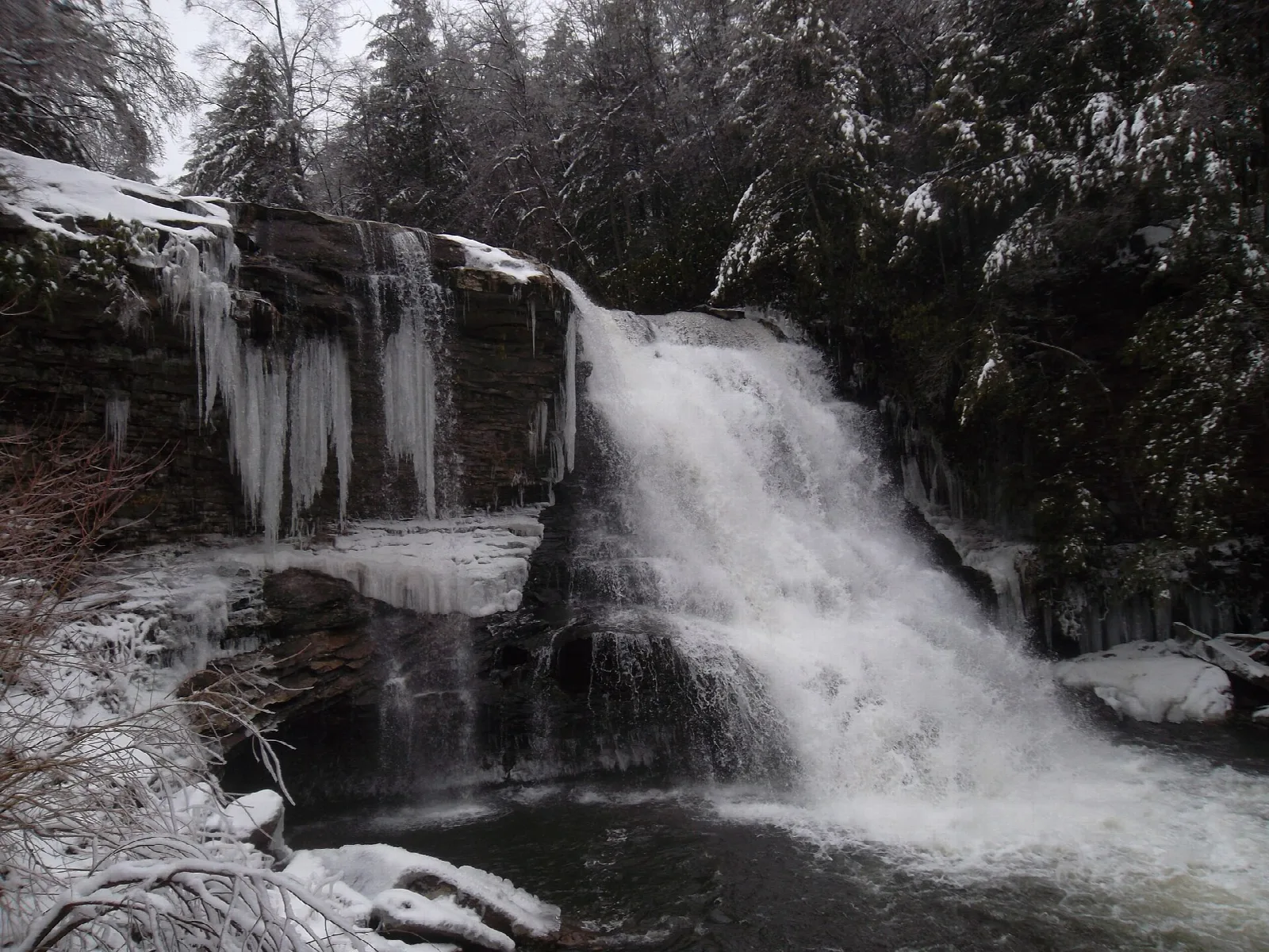 Waterfall with icicles on a rock ledge in winter
