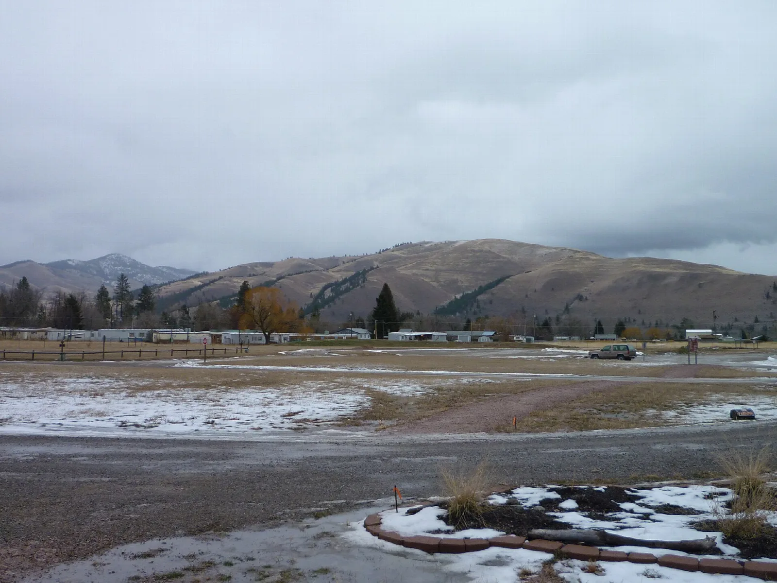 Mountains rising behind a snowy flat with a curving path