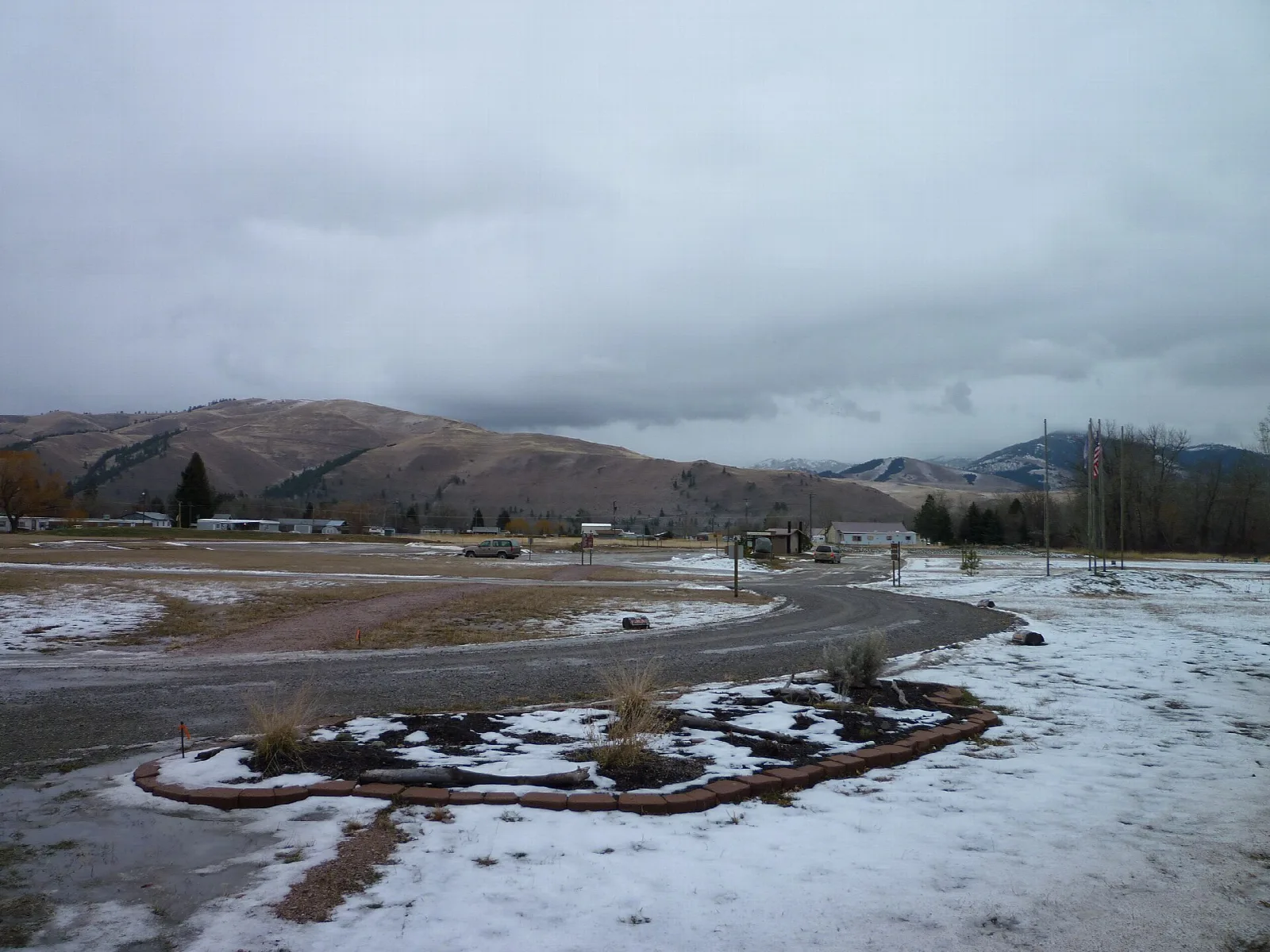 Snow-dusted valley with brown mountains and a rock-edged path