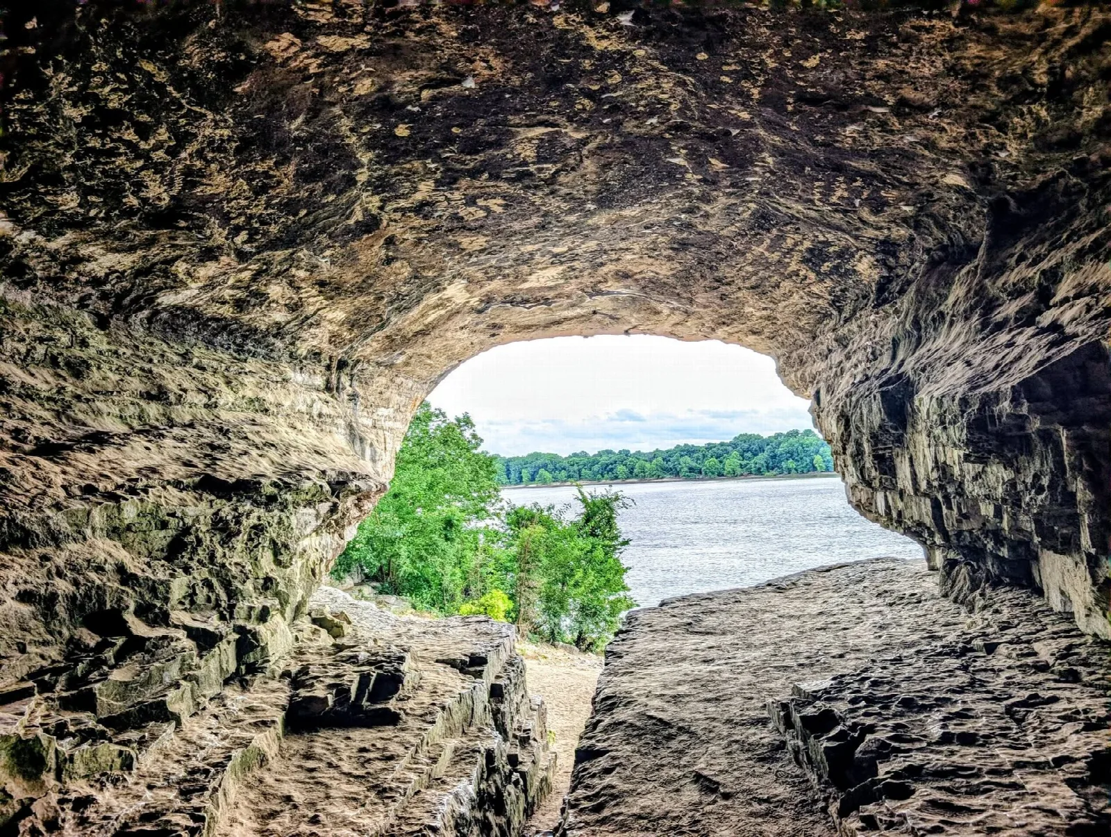 View of the Ohio River and green far bank from inside a cave