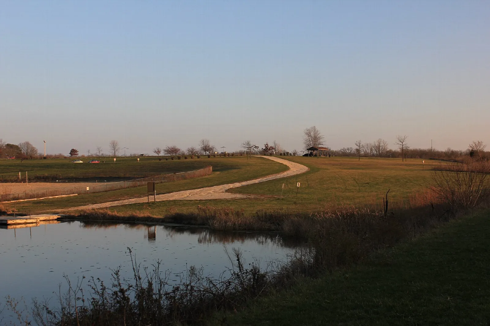 Mown path beside a pond in an open grassy area