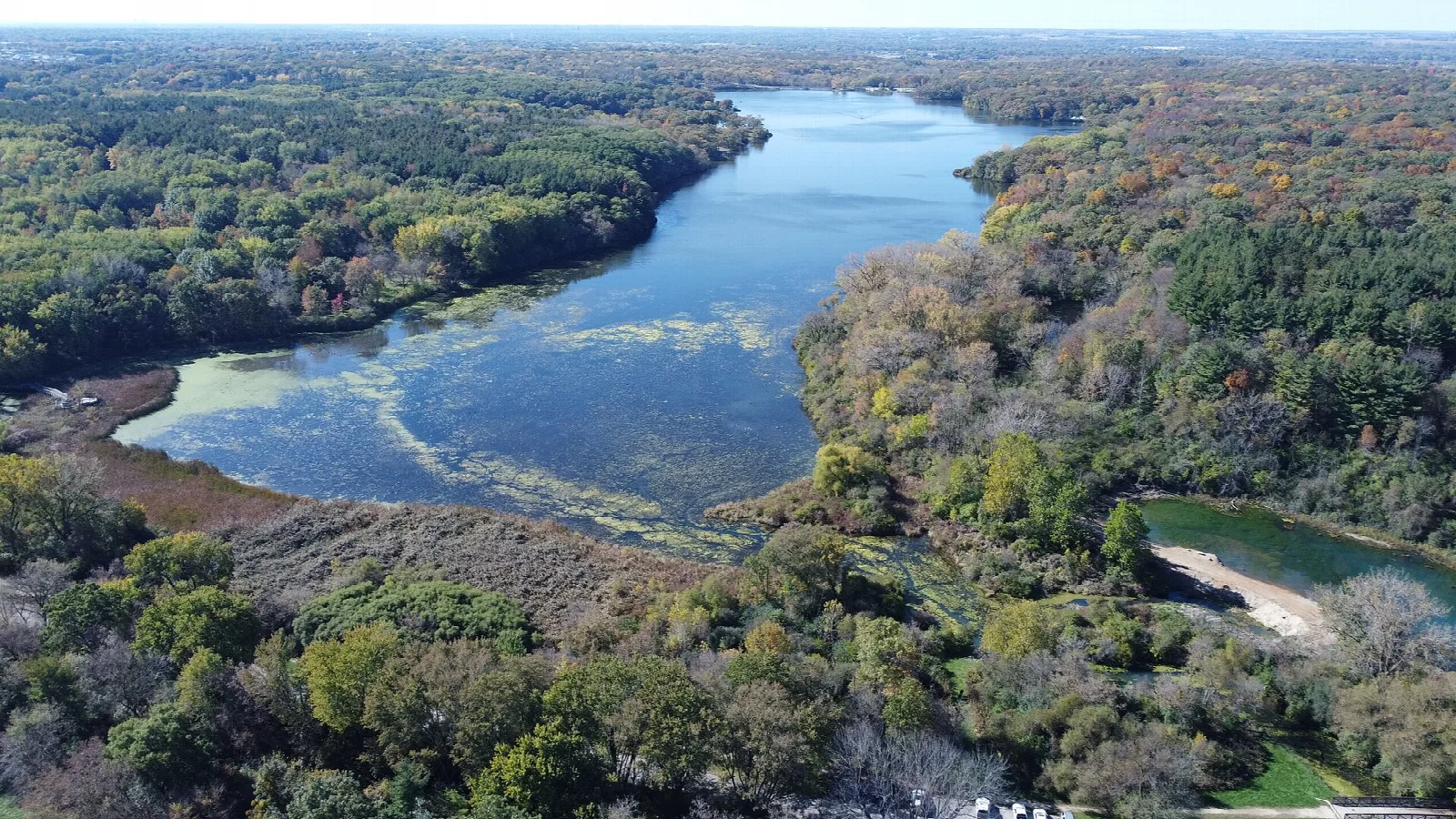Aerial view of a lake winding through forest