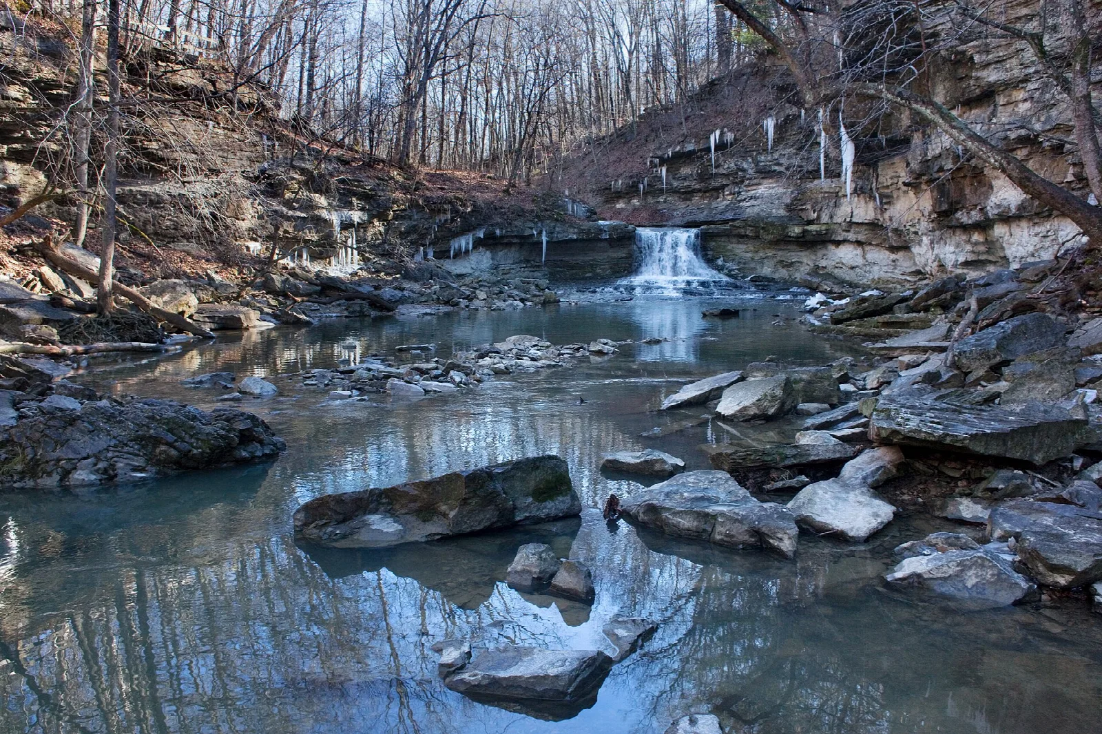 Waterfall and icicles on a rocky creek bed in winter