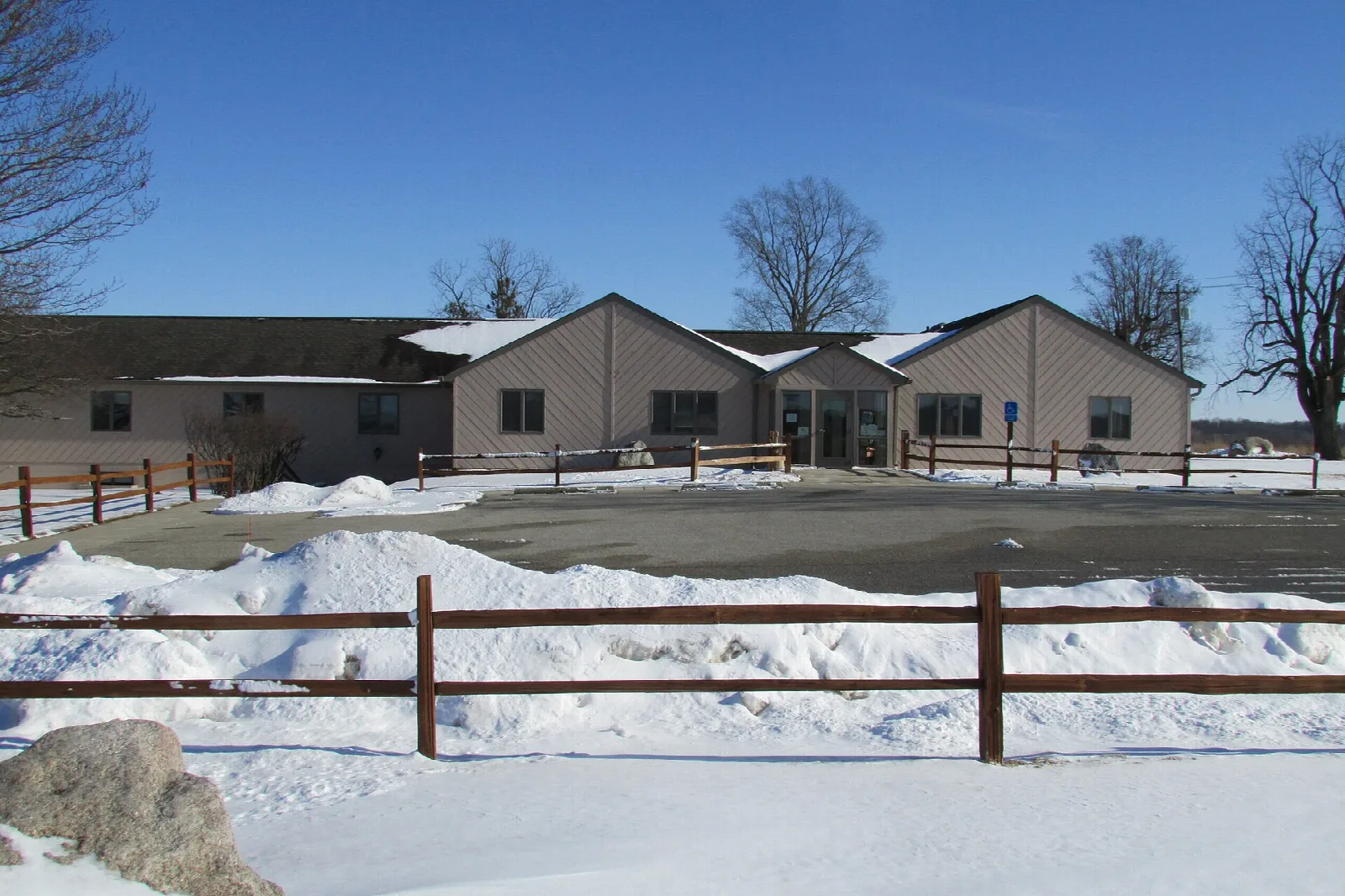 Low tan visitor center building with snow on the ground in front
