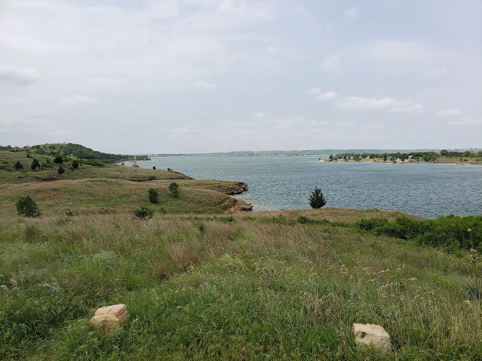 Lake inlet with green grass and rocks in the foreground