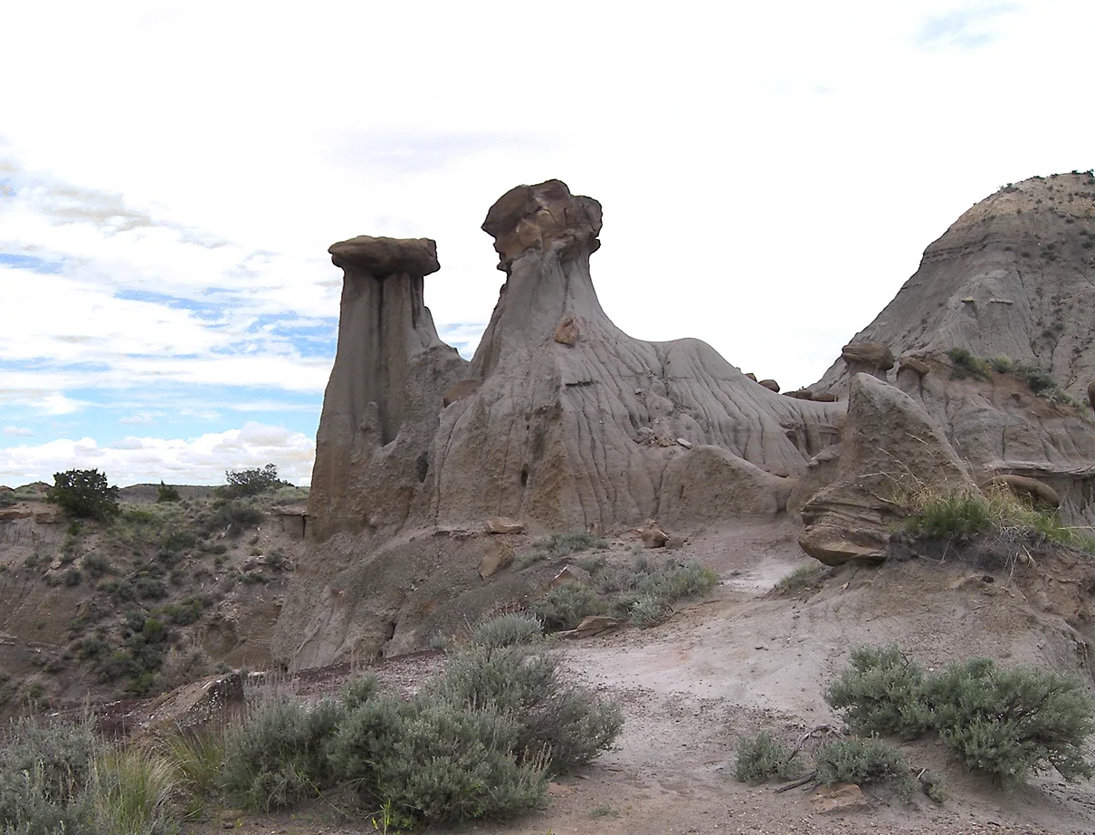 Tall hoodoo rock formations on a dry badland slope