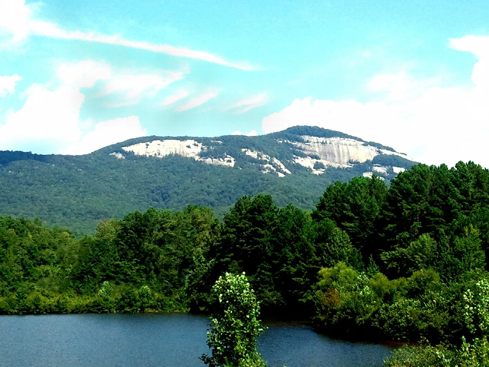 Table Rock Mountain seen across a small lake with green trees in front