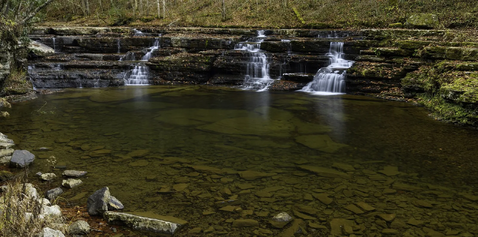 Small stepped waterfalls spilling into a calm pool