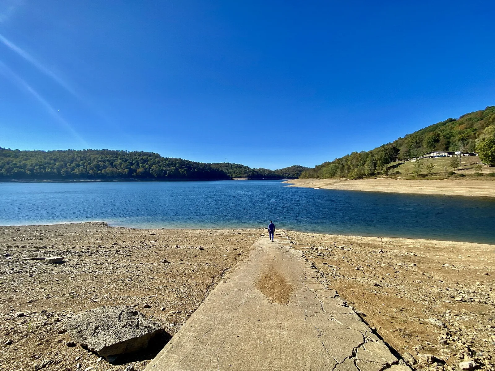 Wide blue lake with a concrete ramp running into the water