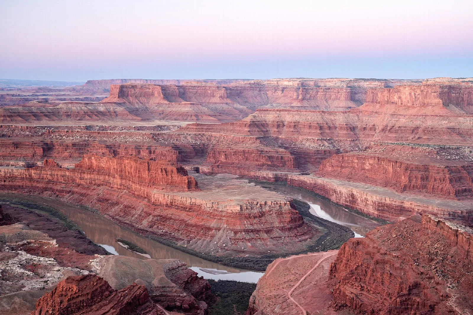 Sunrise light on red canyon walls above a bend in the Colorado River