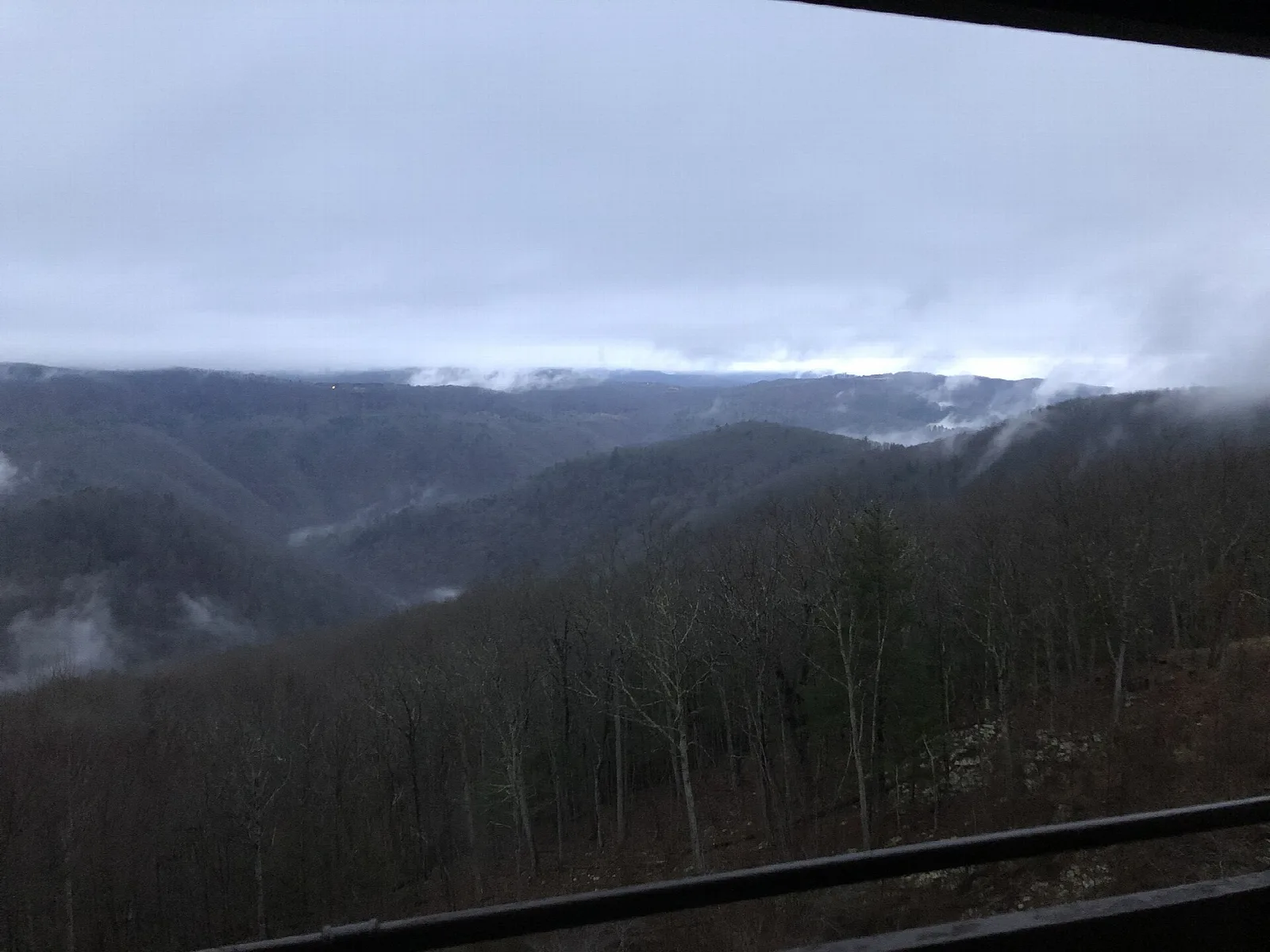 Fog filling a forested gorge seen from a lodge window