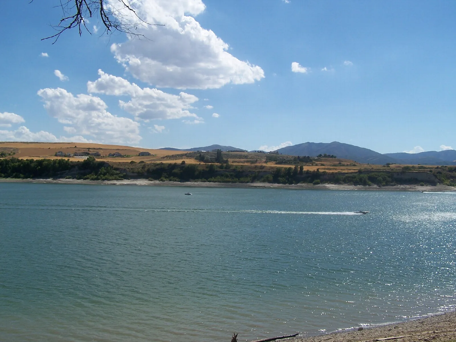 Blue reservoir water under a partly cloudy sky with a far shoreline
