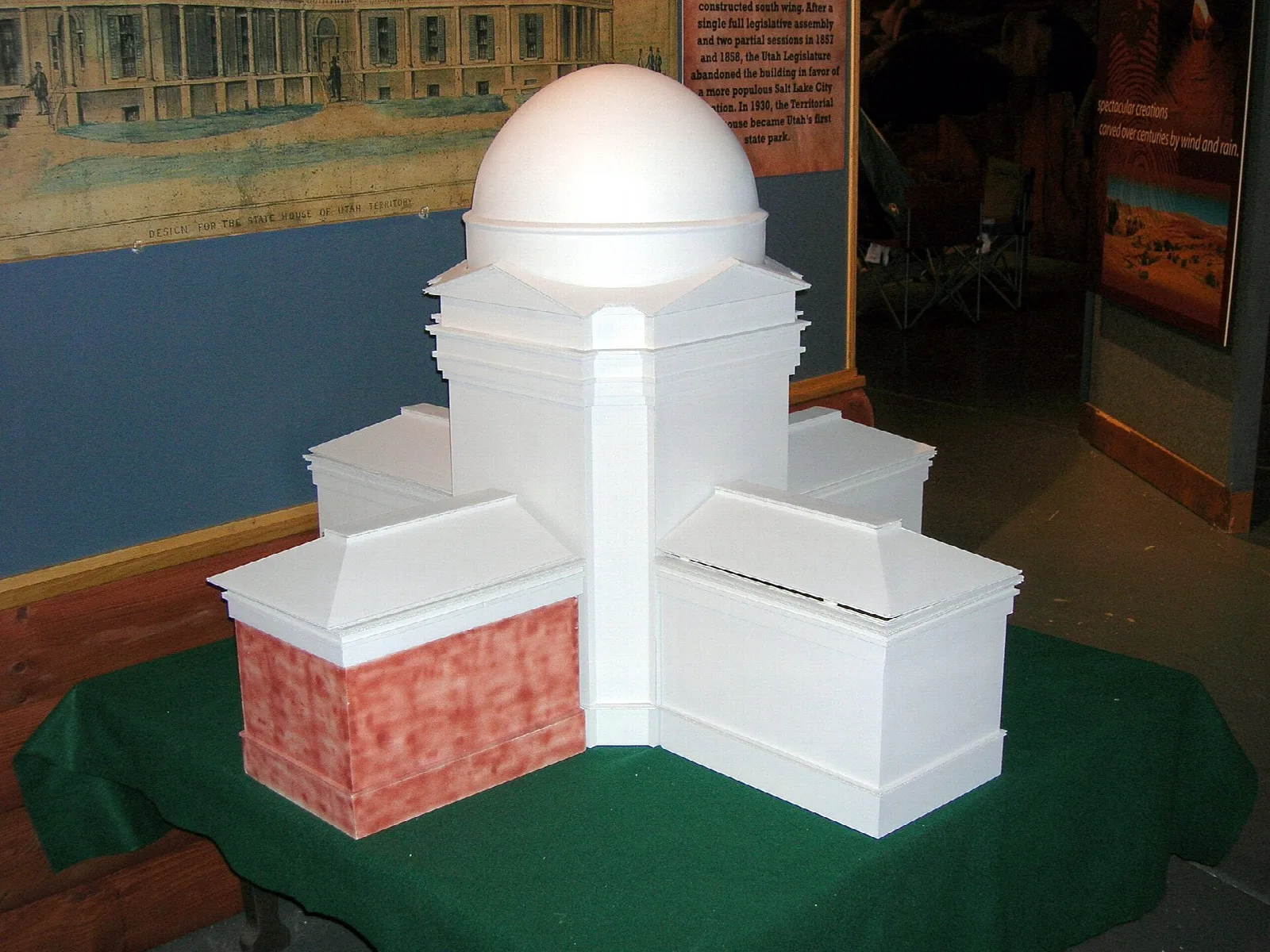White model of a domed statehouse building on a green table in a museum