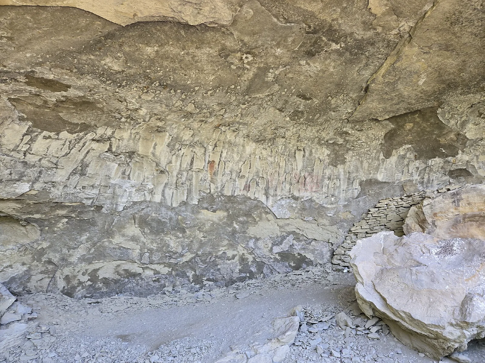 Wide shallow cave with a ceiling of layered sandstone