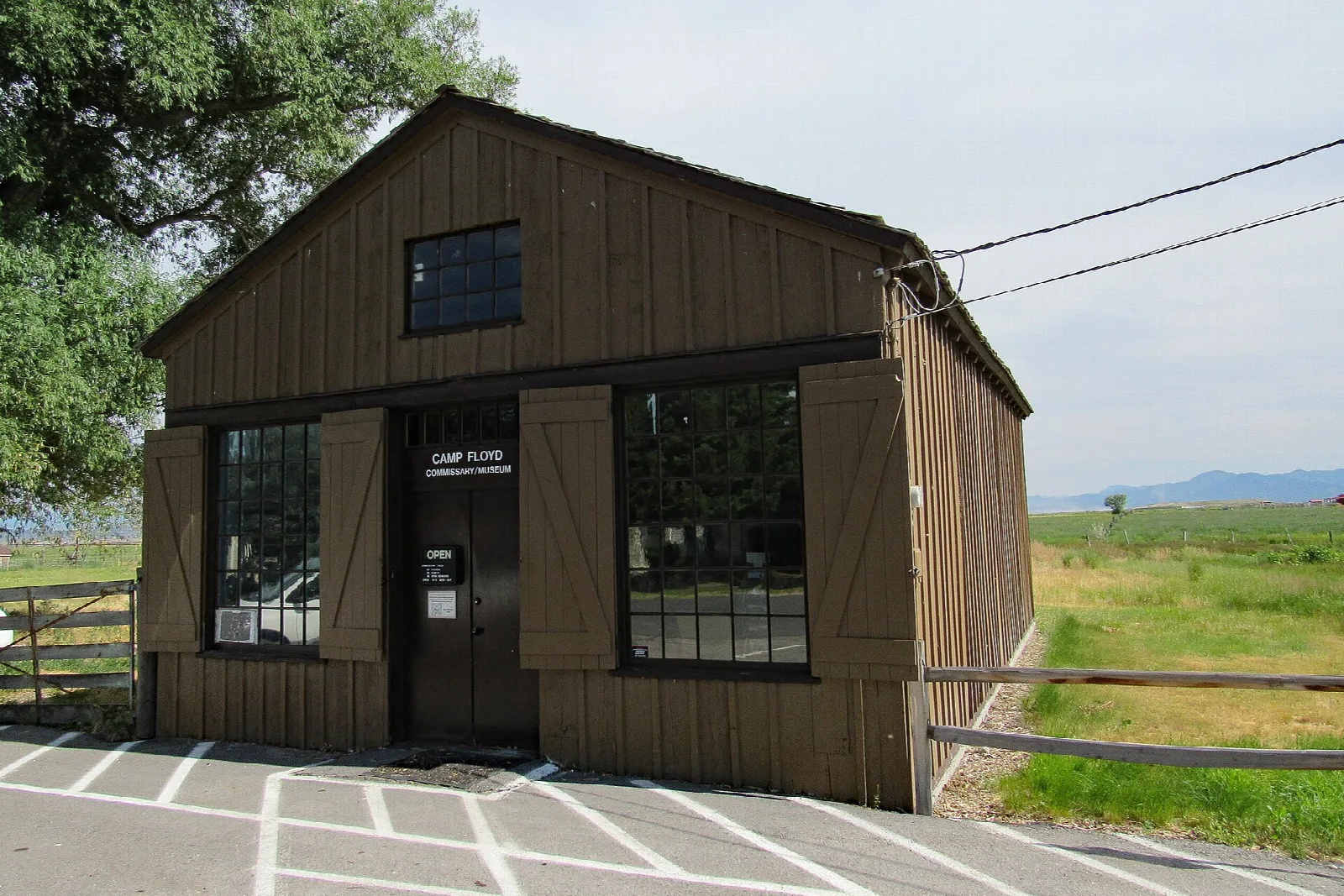 Wooden historic commissary building with a museum sign and a parking area
