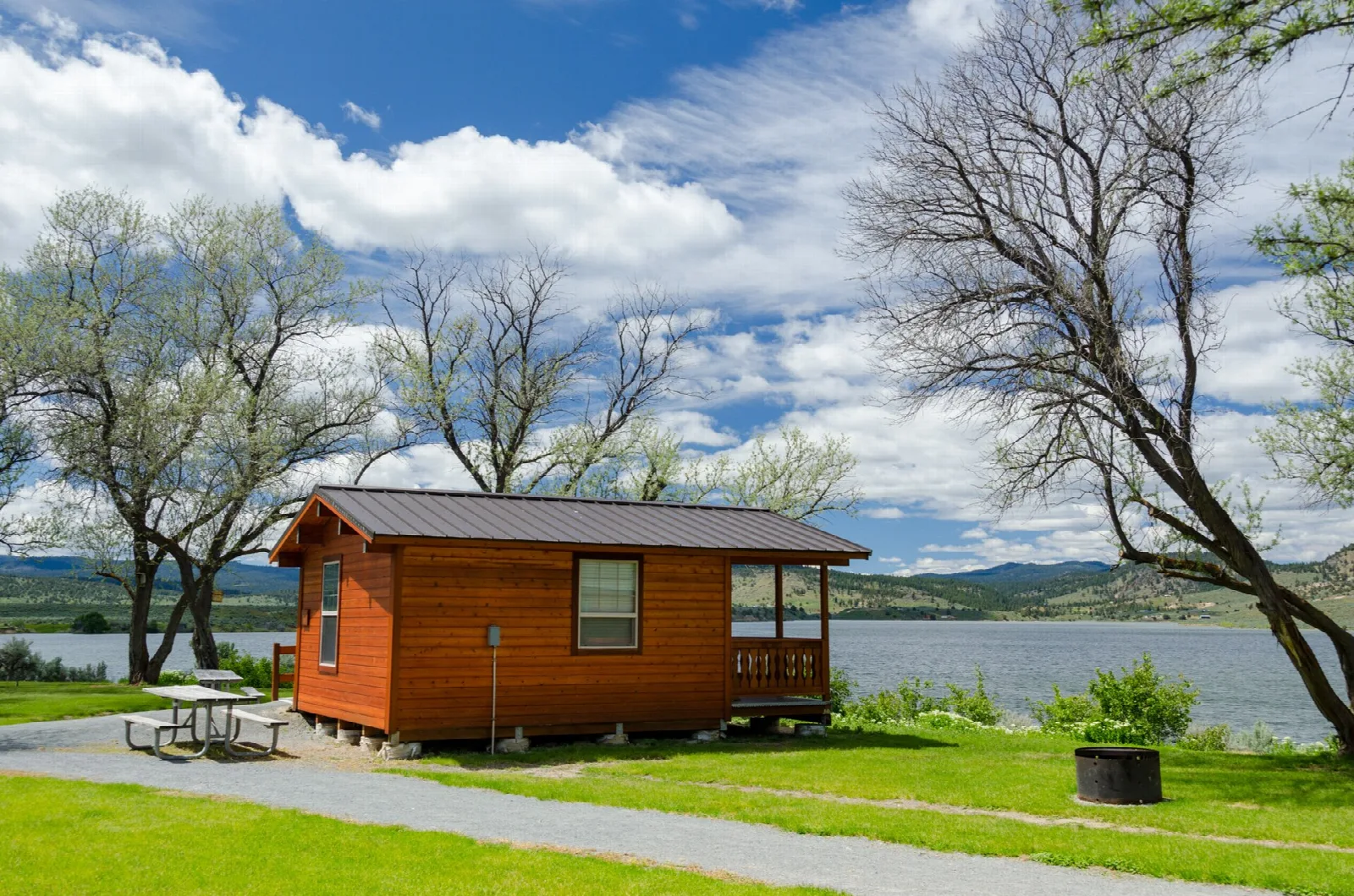 Orange cabin on a green lawn beside the lake