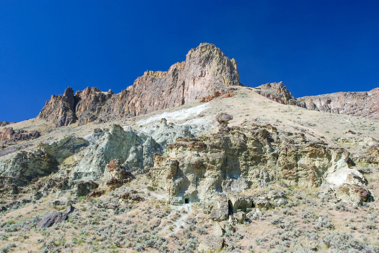 Pale and rust-colored rock formations under blue sky