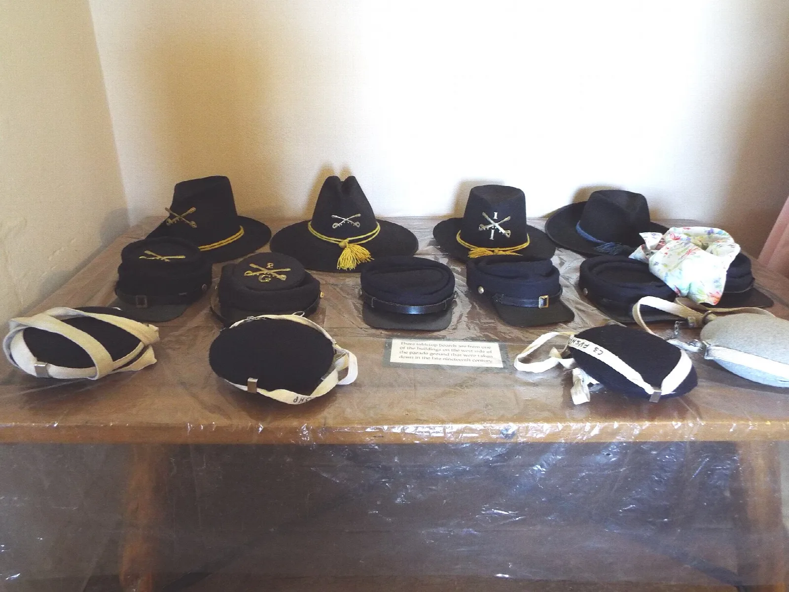 Table of old military hats and caps in a museum room