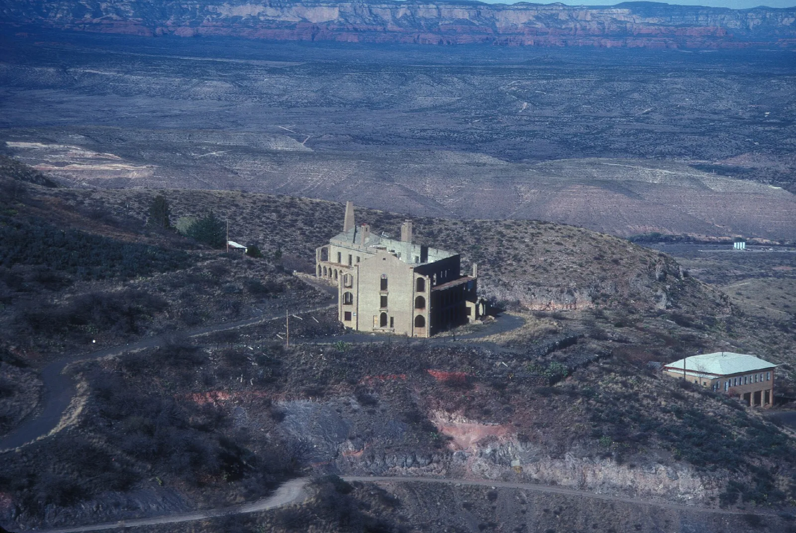 Aerial view of the mansion on a hillside above a wide valley