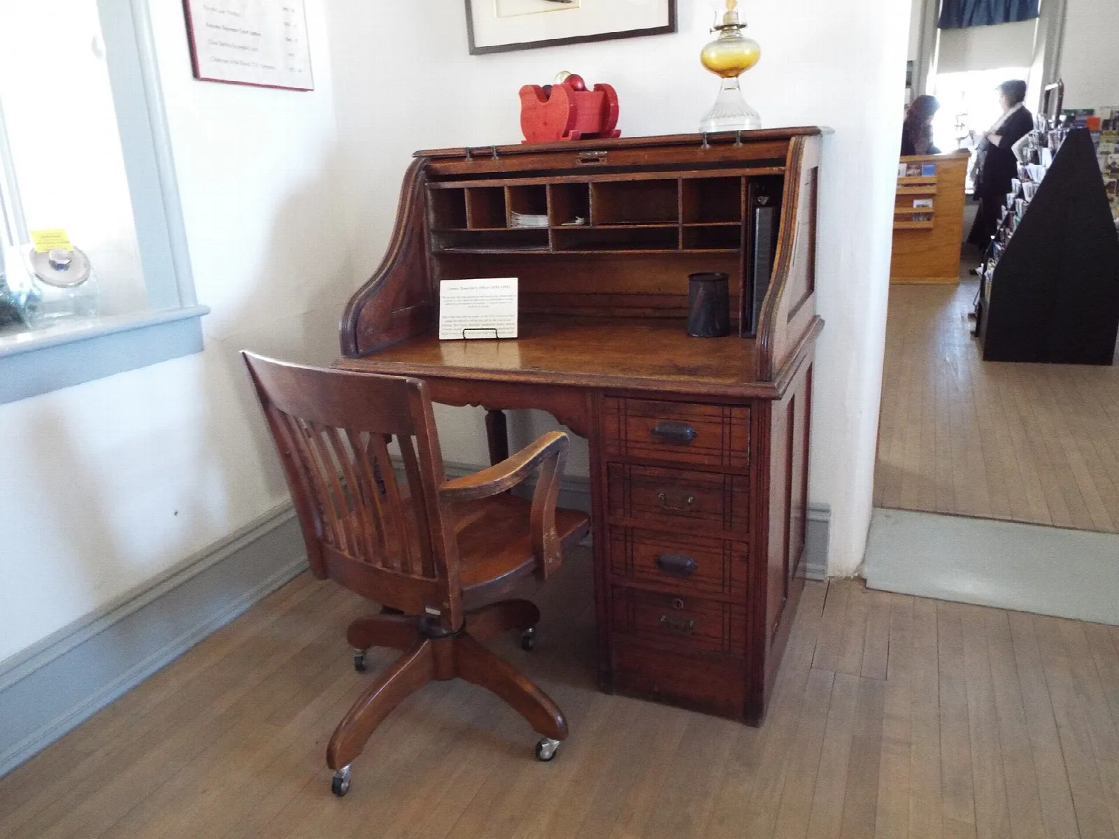 Wooden roll-top desk and chair in a museum office